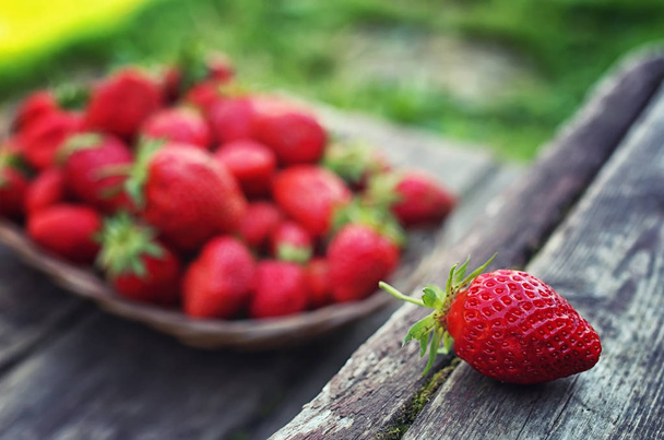 Erdbeere im Weidenteller auf Holzhintergrund - Foto, Bild