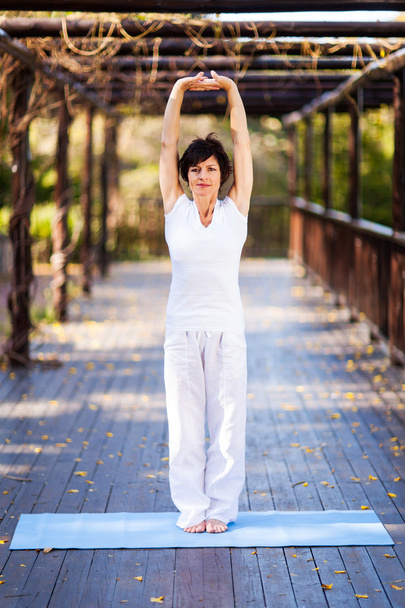 Middle aged woman stretching outdoors - Foto, immagini
