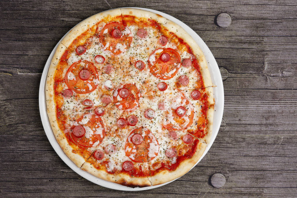 Pepperoni pizza on wooden table, top point of view. - Foto, Imagen