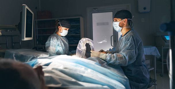 doctor and an assistant in the operating room for surgical venous vascular surgery clini - Photo, Image