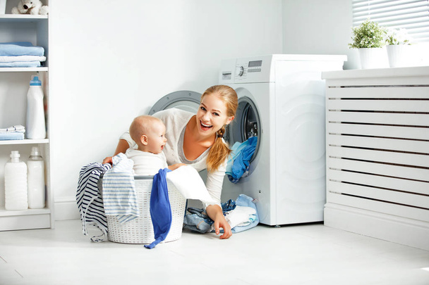 mère femme au foyer avec bébé engagé dans des vêtements de pli de blanchisserie dans
  - Photo, image
