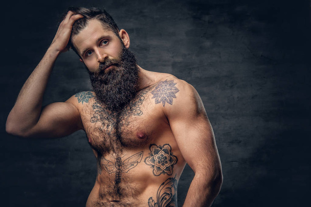 Homem barbudo sem camisa com tronco tatuado
 - Foto, Imagem
