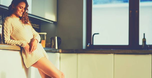 Young woman standing in kitchen - Foto, imagen