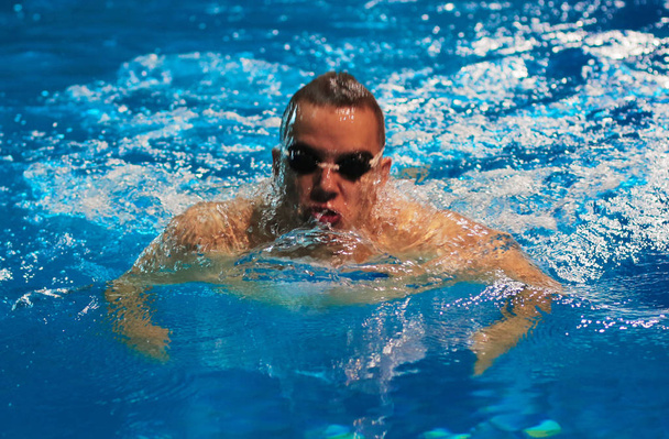 Мужчина плавает в бассейне. Подводное фото
 - Фото, изображение