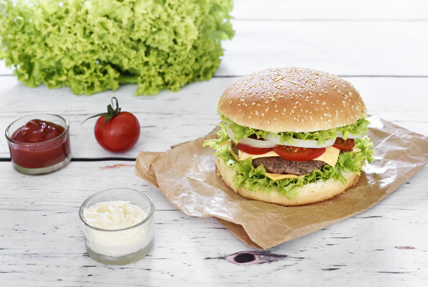Čerstvé, lahodné hamburger nebo cheeseburger s omáčkami  - Fotografie, Obrázek