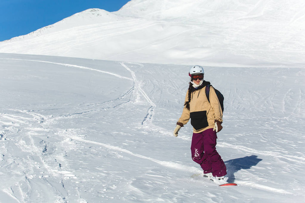 vrouwen snowboarder snowboarden op verse witte sneeuw met skihelling op zonnige winterdag - Foto, afbeelding