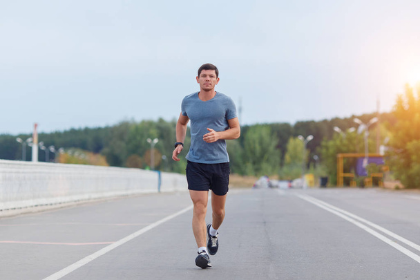 Jogging lifestyle - young attractive man running outdoors - Photo, Image