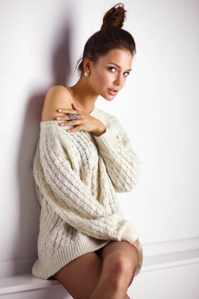 Portrait of a cute woman in sweater at home - 写真・画像