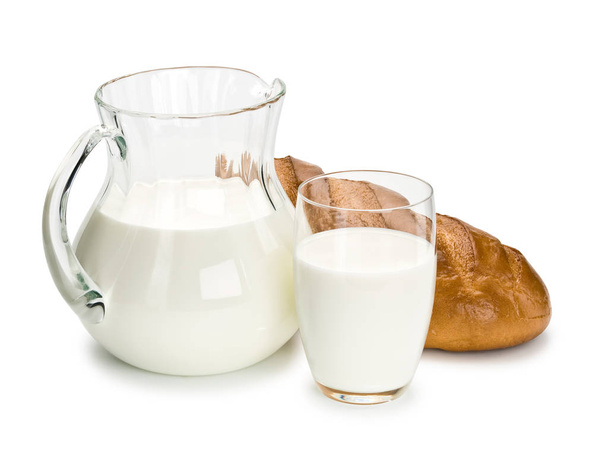 Glassware filled with milk and a white loaf long loaf - Foto, imagen