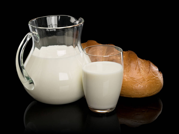 Glassware filled with milk and a white loaf long loaf - Foto, Imagem
