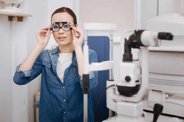 Beautiful good looking woman putting on eye test glasses - Photo, Image