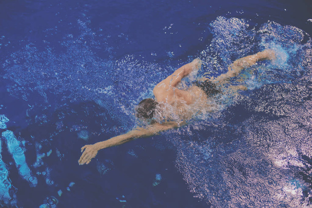 Male swimmer at the swimming pool. Underwater photo - Foto, afbeelding