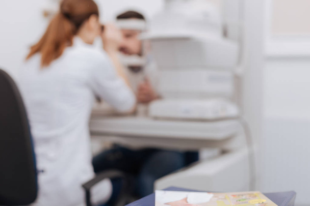 Blurred image of an ophthalmologist examining the eyesight - Foto, Imagen