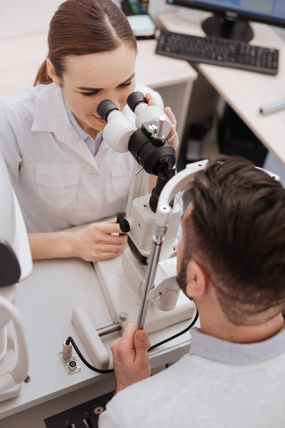 Top view of a female optician examining her patient - Foto, imagen