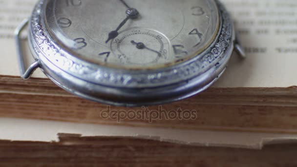 Vintage starožitné kapesní hodinky na pozadí starých knih - Záběry, video