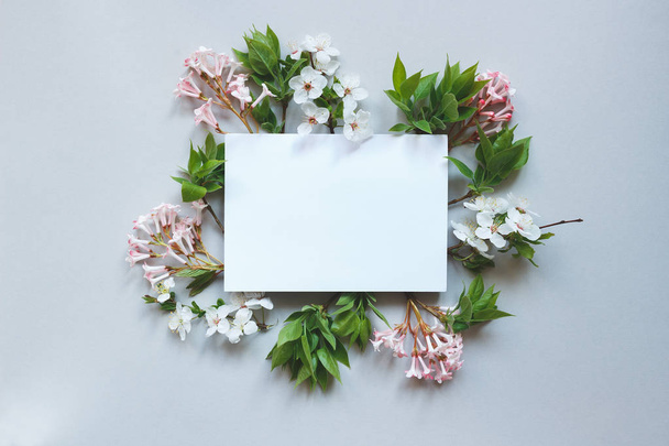 Spring background with paper sheet. Beautiful fresh flowers and  - 写真・画像