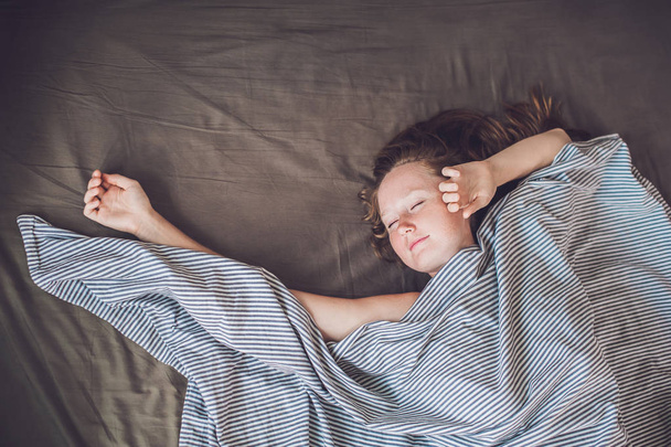 young woman lying down in bed - Fotó, kép