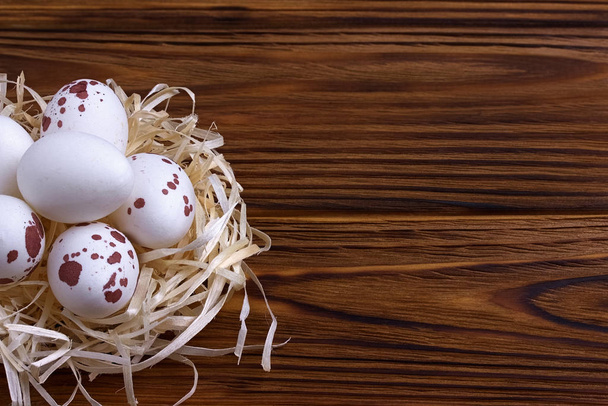 Decoración de Pascua, huevos de Pascua en el nido sobre fondo de madera marrón
. - Foto, Imagen