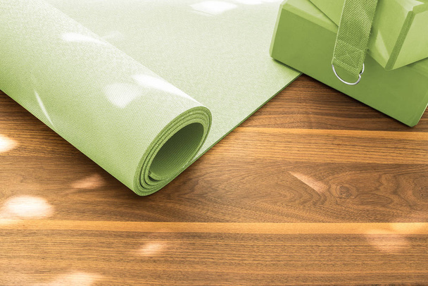 Yoga mat on a wooden background. Equipment for yoga. - Φωτογραφία, εικόνα