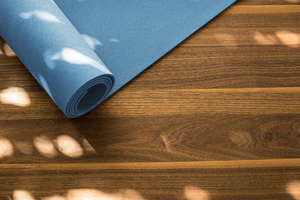 Yoga mat on a wooden background. Equipment for yoga.  - 写真・画像