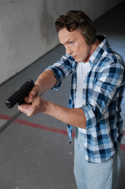Handsome good looking man directing his handgun - Foto, Imagen