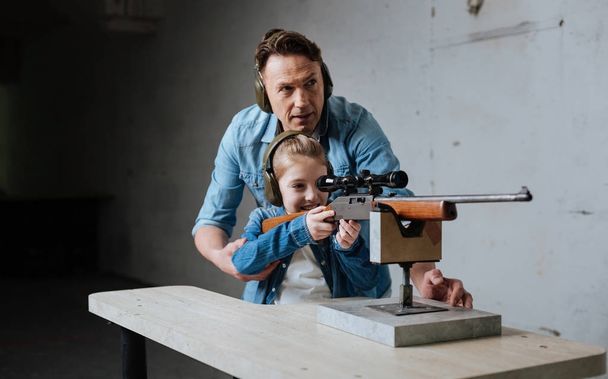 Nice cute girl learning to use a gun - Foto, Bild