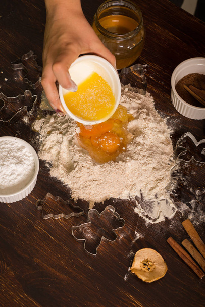 Preparing pastry for gingerbread. Pouring melted butter to flour. - Photo, Image