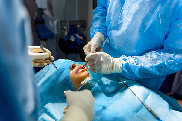 Busy doctors operating female patient - Valokuva, kuva
