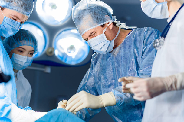 Assembled doctors tensely doing operation - Фото, зображення