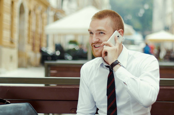Człowiek na smartphone - młody biznes człowiek rozmawia inteligentny telefon. - Zdjęcie, obraz