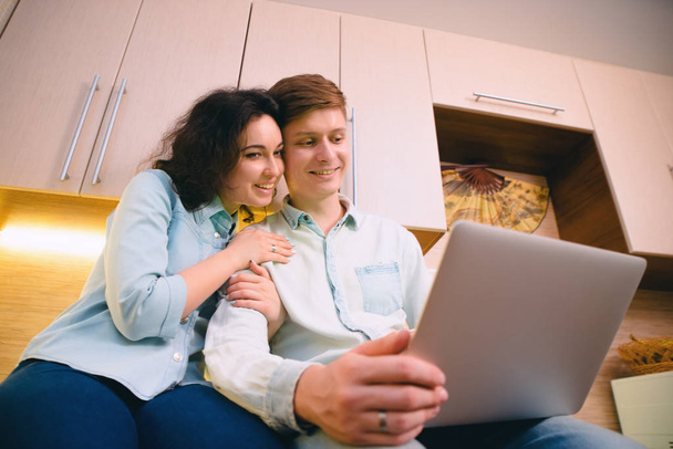 Couple with laptop in kitchen - Photo, Image