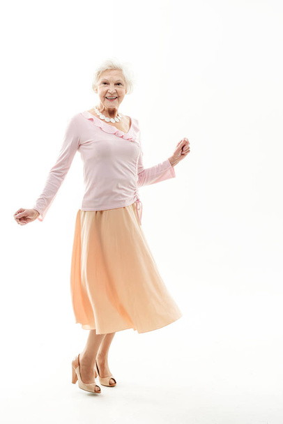 Carefree senior lady posing in skirt - 写真・画像
