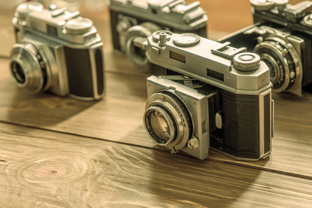 Vintage cameras and lenses on wooden background - Photo, Image