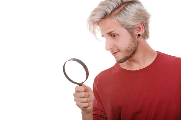 man holds on eye magnifying glass looking through loupe - Φωτογραφία, εικόνα