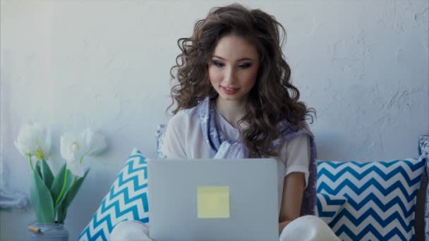 Молода жінка, спілкуватися в чаті з друзями в Інтернеті на ноутбук - Кадри, відео