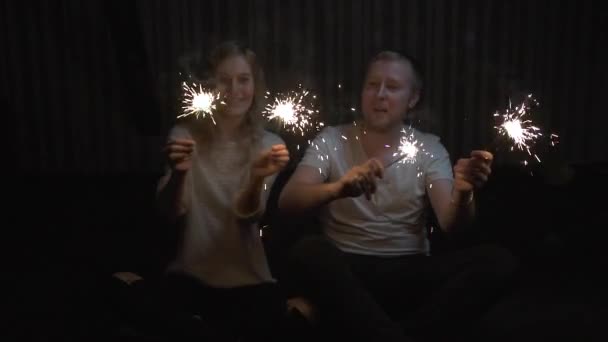 Młoda dziewczyna i facet trzyma ognie i uśmiechając się. zwolnionym tempie - Materiał filmowy, wideo