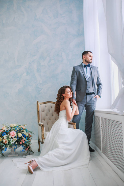 A woman holding a mans hand. Bride in beautiful dress and groom - Zdjęcie, obraz