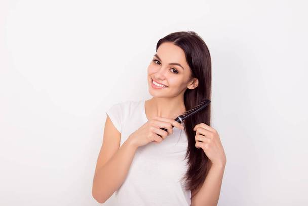 Happy young woman combing her long healthy hair on white backgro - 写真・画像