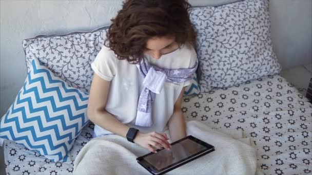 Mooie vrouw met behulp van Tablet PC computer online winkelen op het huis zittend op bed. - Video