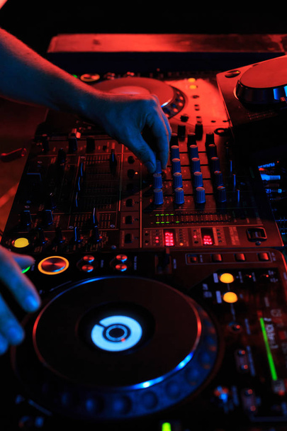 DJ playing music in night club party. Turntable equipment in dar - Foto, Imagen