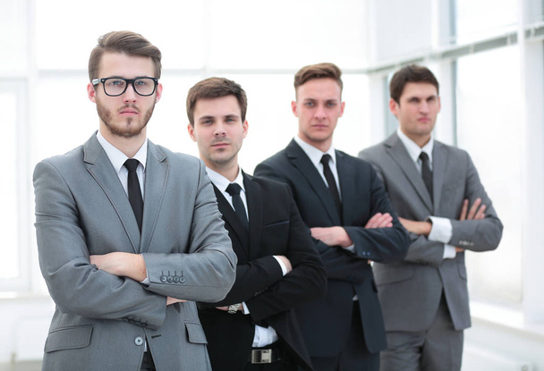 Confident business team standing in front of a bright window - 写真・画像