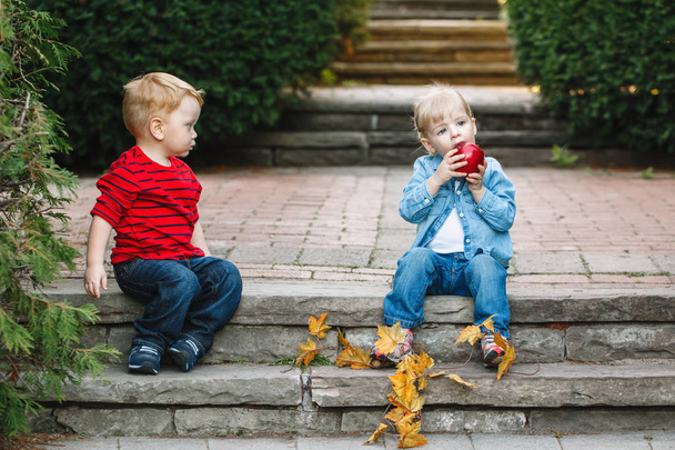 niños sentados juntos compartiendo manzana
 - Foto, Imagen