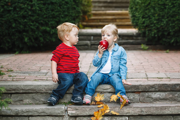 niños sentados juntos compartiendo manzana
 - Foto, imagen
