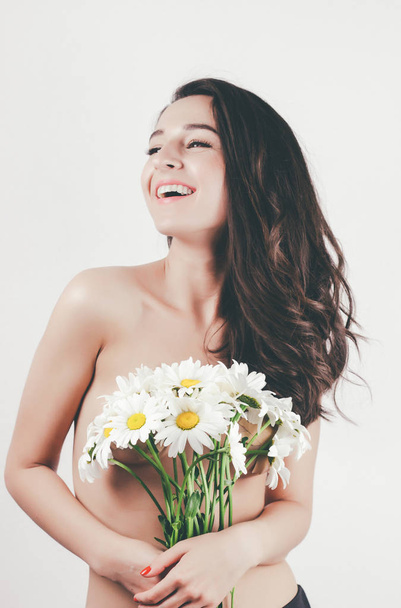 нежная милая красивая летняя девушка с топлесс тело идеальной кожи. держит цветы ромашки. белый фон
 - Фото, изображение
