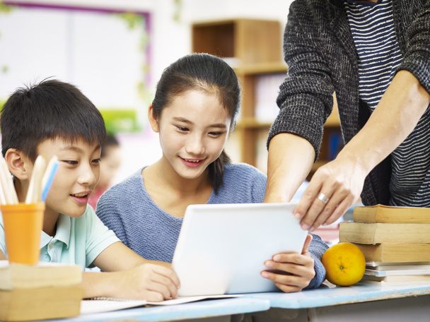 asiático elemental escolar utilizando digital tablet en classroo
 - Foto, Imagen