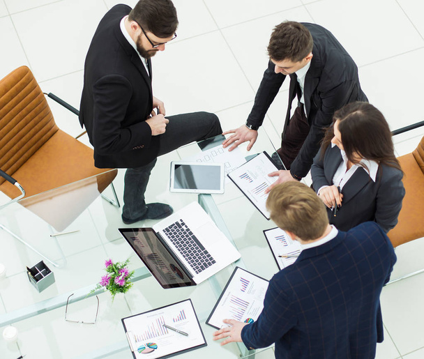 succesvolle business team bespreken marketing graphics vóór de vergadering - Foto, afbeelding