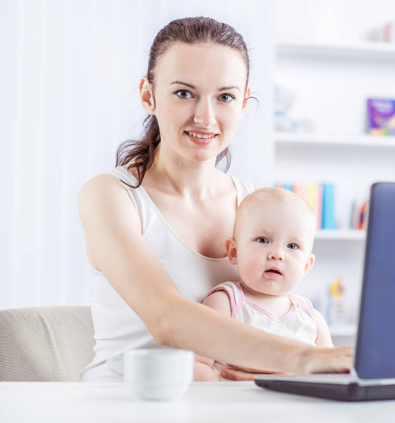 young mother and baby using laptop to communicate with grandma via skype - Fotó, kép