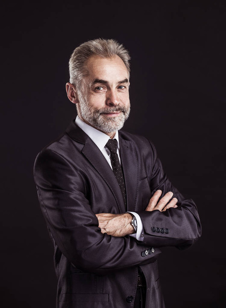 portrait of successful businessman with arms crossed on black background. - Фото, изображение