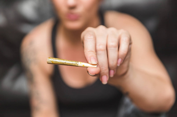 Rolled Joint in Woman's Hand - 写真・画像