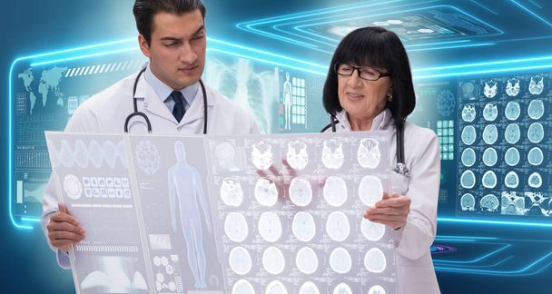Kadın ve erkek doktor MRI görüntülerine bakıyor. - Fotoğraf, Görsel